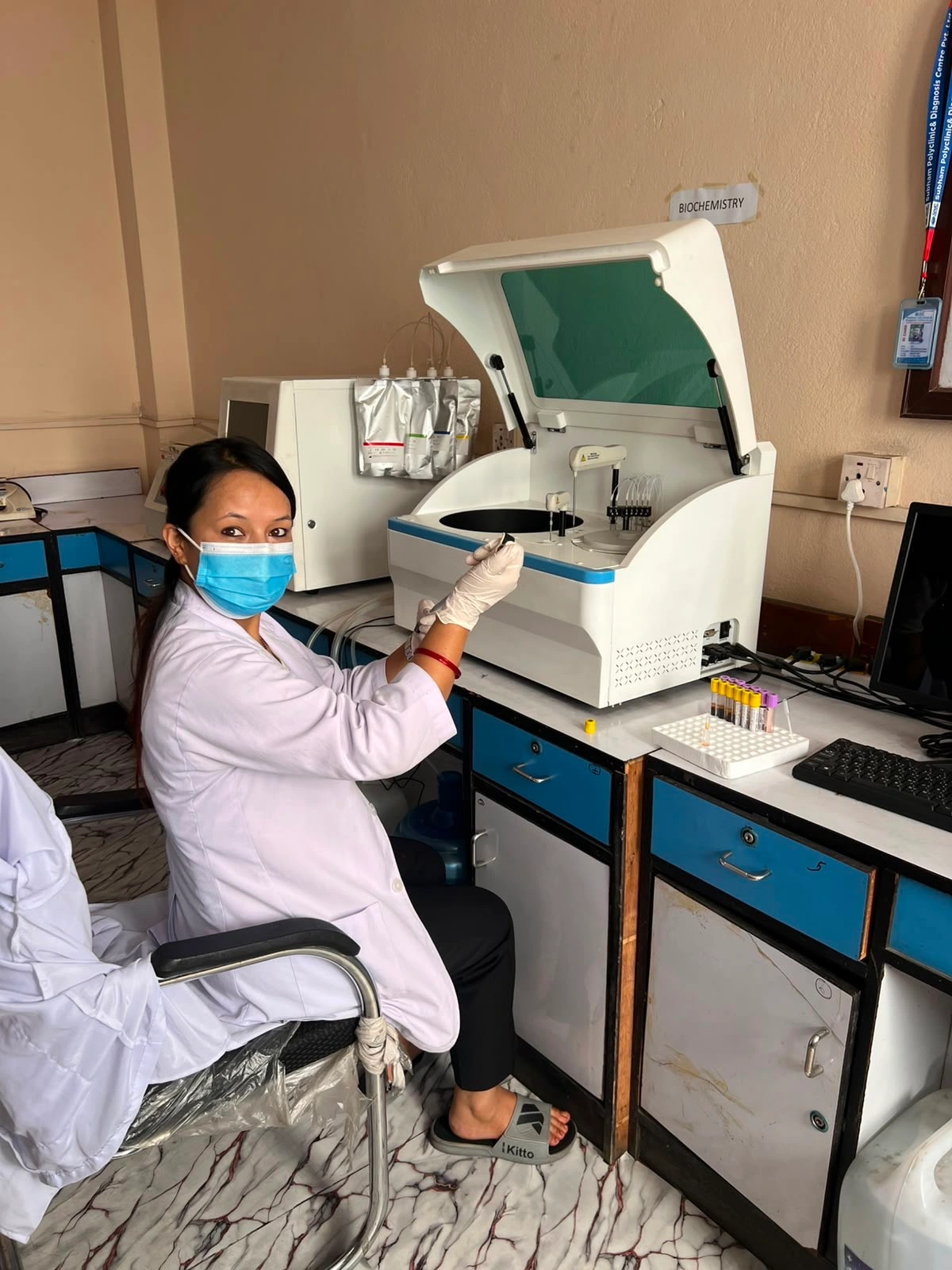 Janasewa laboratory technician preparing a sample beside the biochemistry analyzer